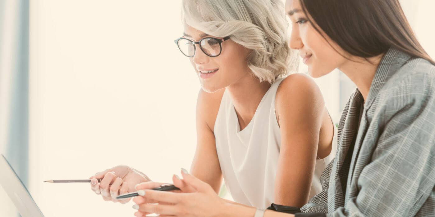 "two professionals reviewing a security incident report on a laptop, collaborating on data analysis and response strategies.