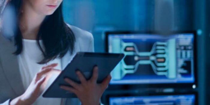 Woman on tablet with computer monitor behind her risks for it teams