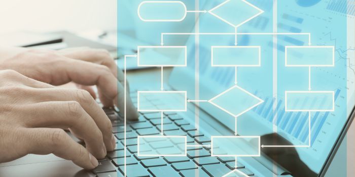 Male hands typing on laptop with digital icons imposed above keyboard representing document management (working papers) and risk management reporting