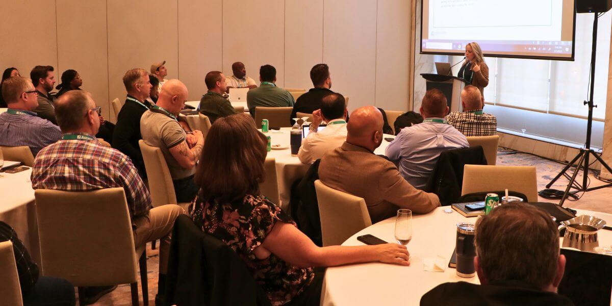 A speaker presents to a full room at the ascend 2025 conference, as ethics and compliance professionals listen and take notes during a focused breakout session.