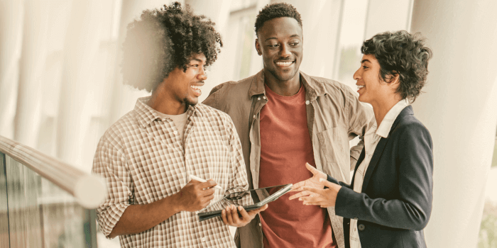 Two men and a woman standing in a row looking at each other and smiling representing risk maturity model
