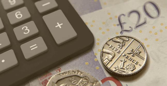 Black calculator in top right of frame over british currency representing uk sox compliance